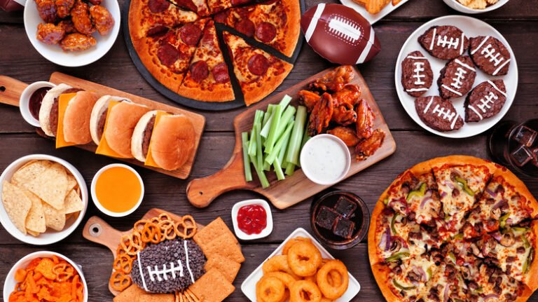 Super Bowl or football theme food table scene, overhead view on dark wood